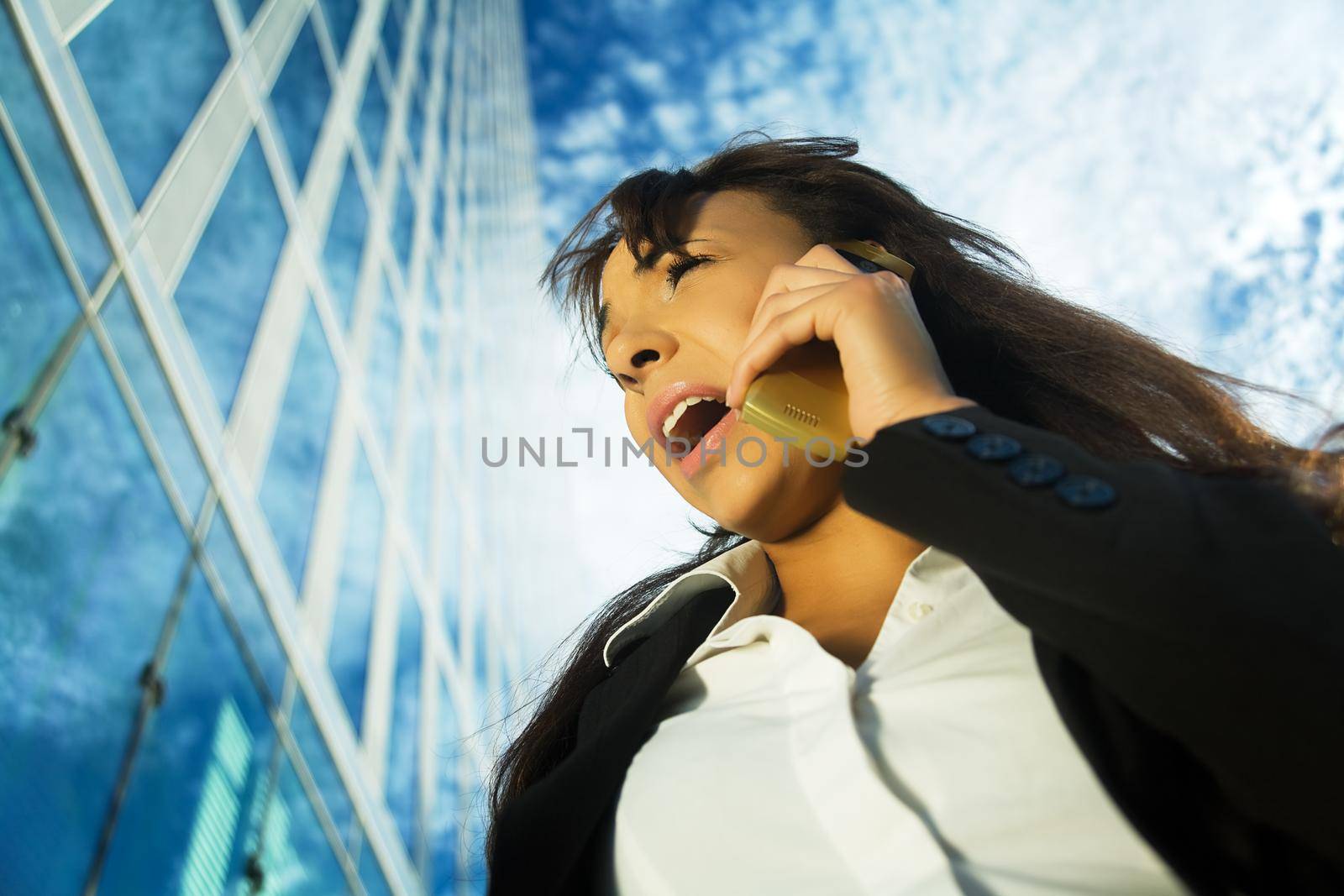 A young brunette professional using her cell phone, shouting at it or receiving not so good news