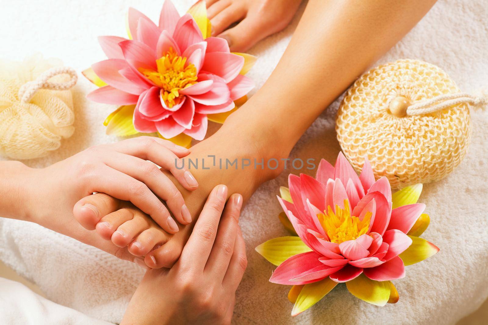 Woman enjoying a feet massage in a spa setting (close up on feet)