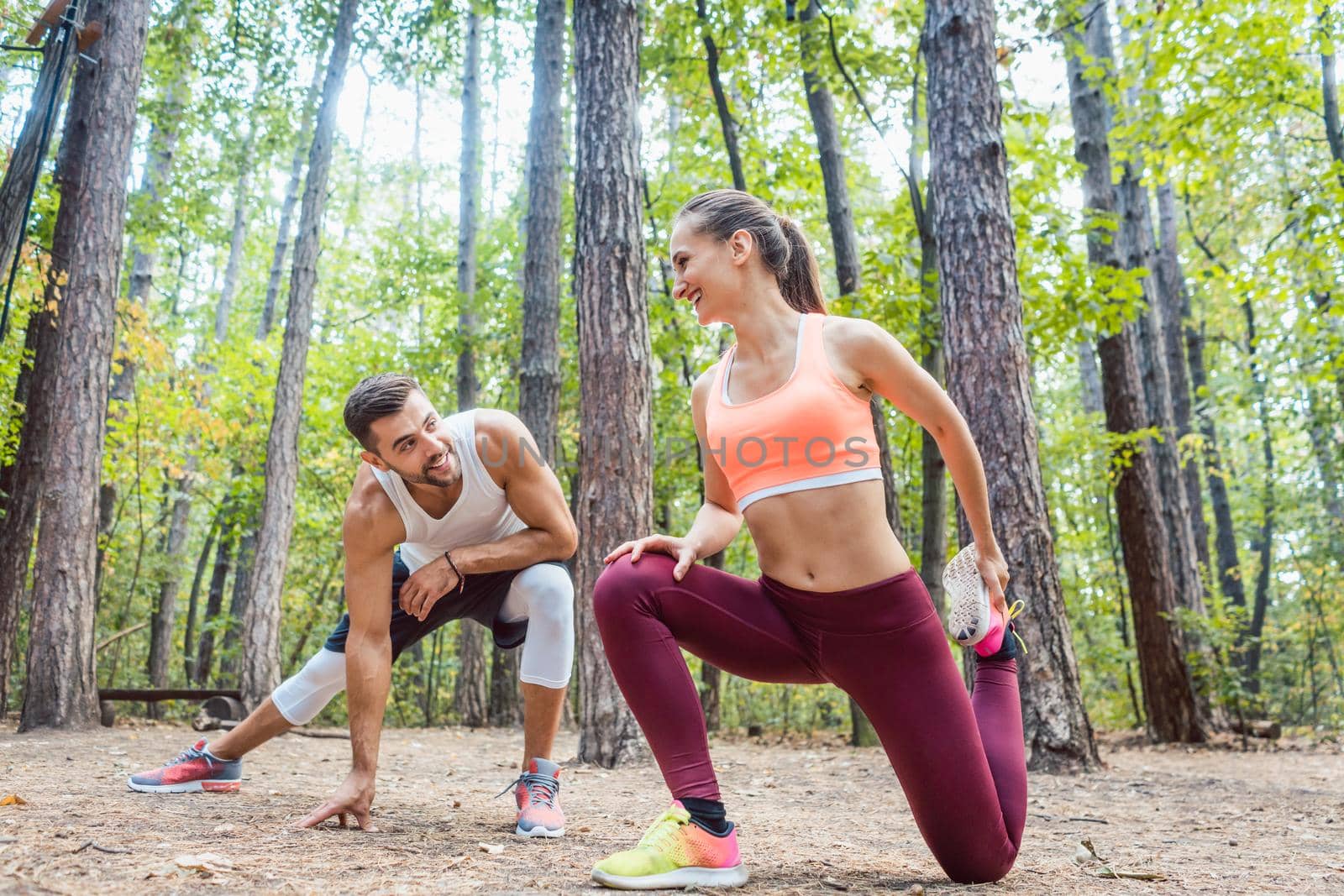 Man and woman warming up and stretching before exercise outdoors