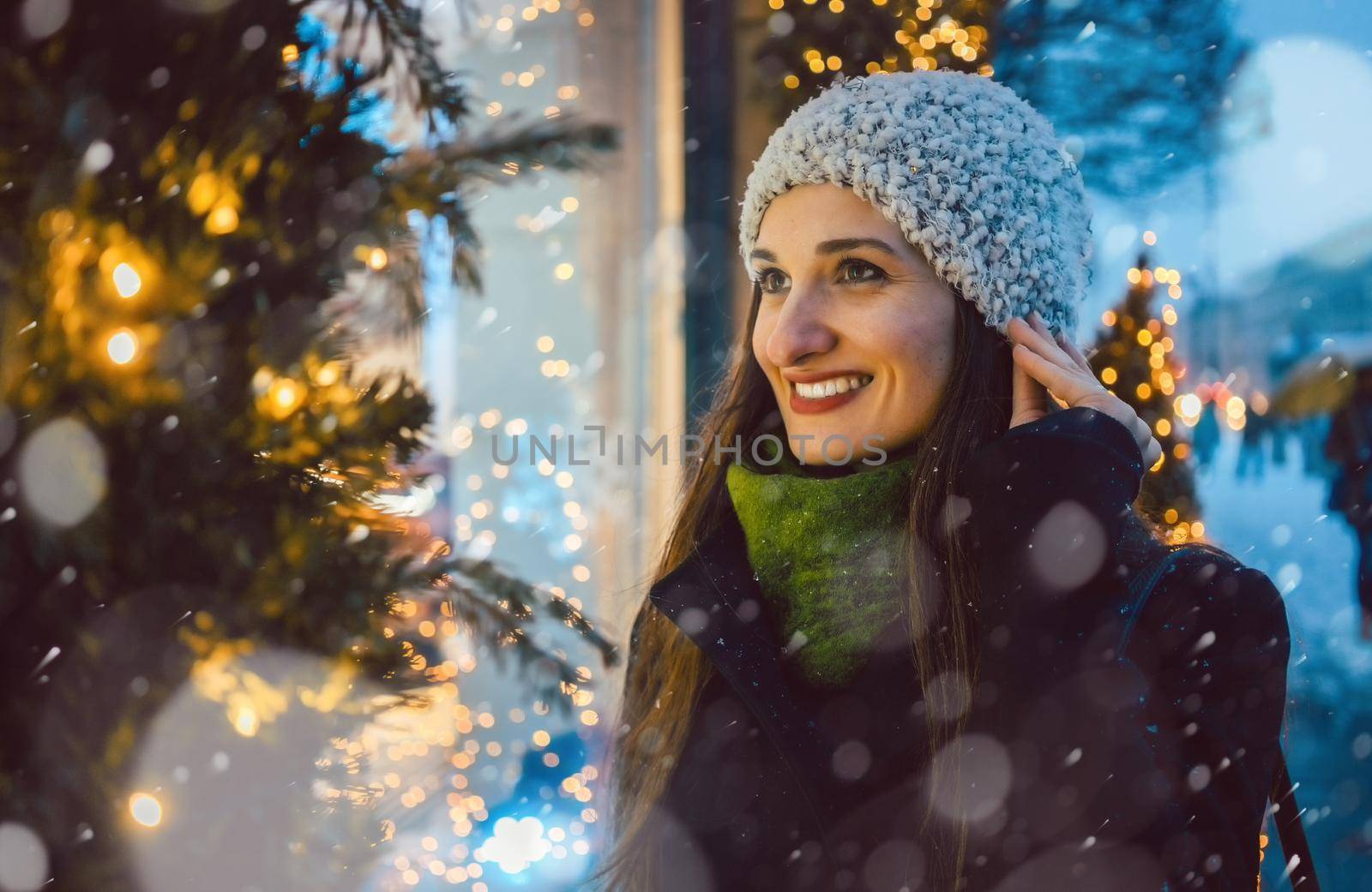 Woman looking in shop window on Christmas shopping gifts