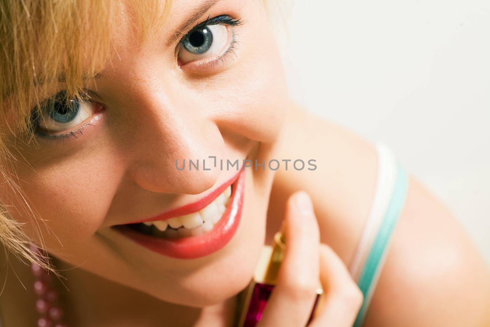 Beautiful woman using perfume and enjoying it visibly