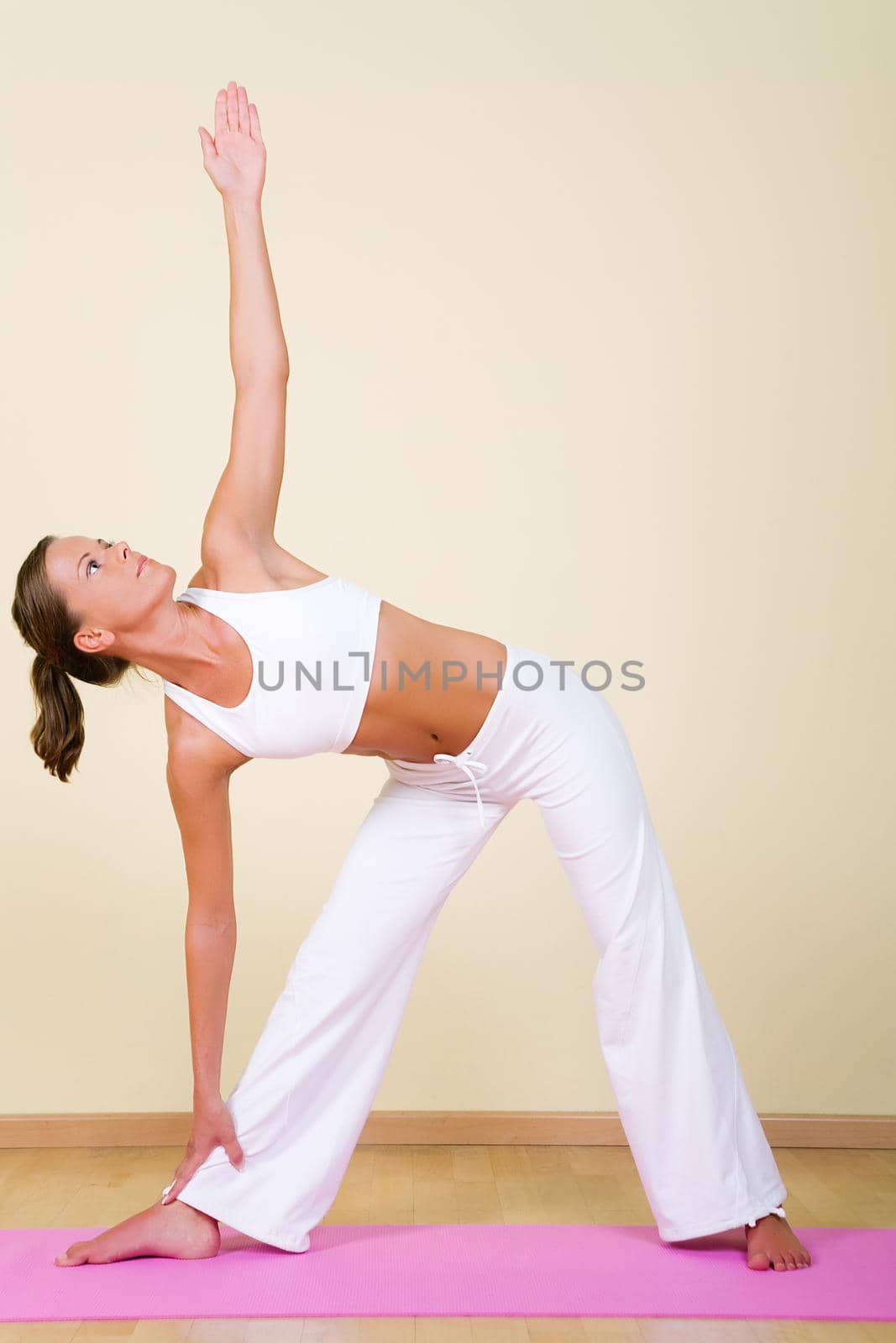 Young woman in a yoga position (Utthita Trikonasana)