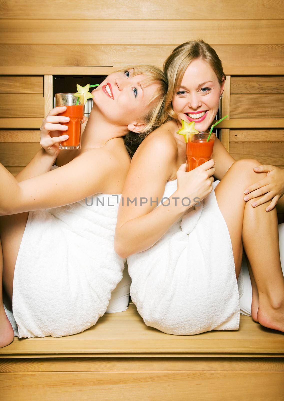 Two friends (female) enjoying vitamin drinks in a sauna