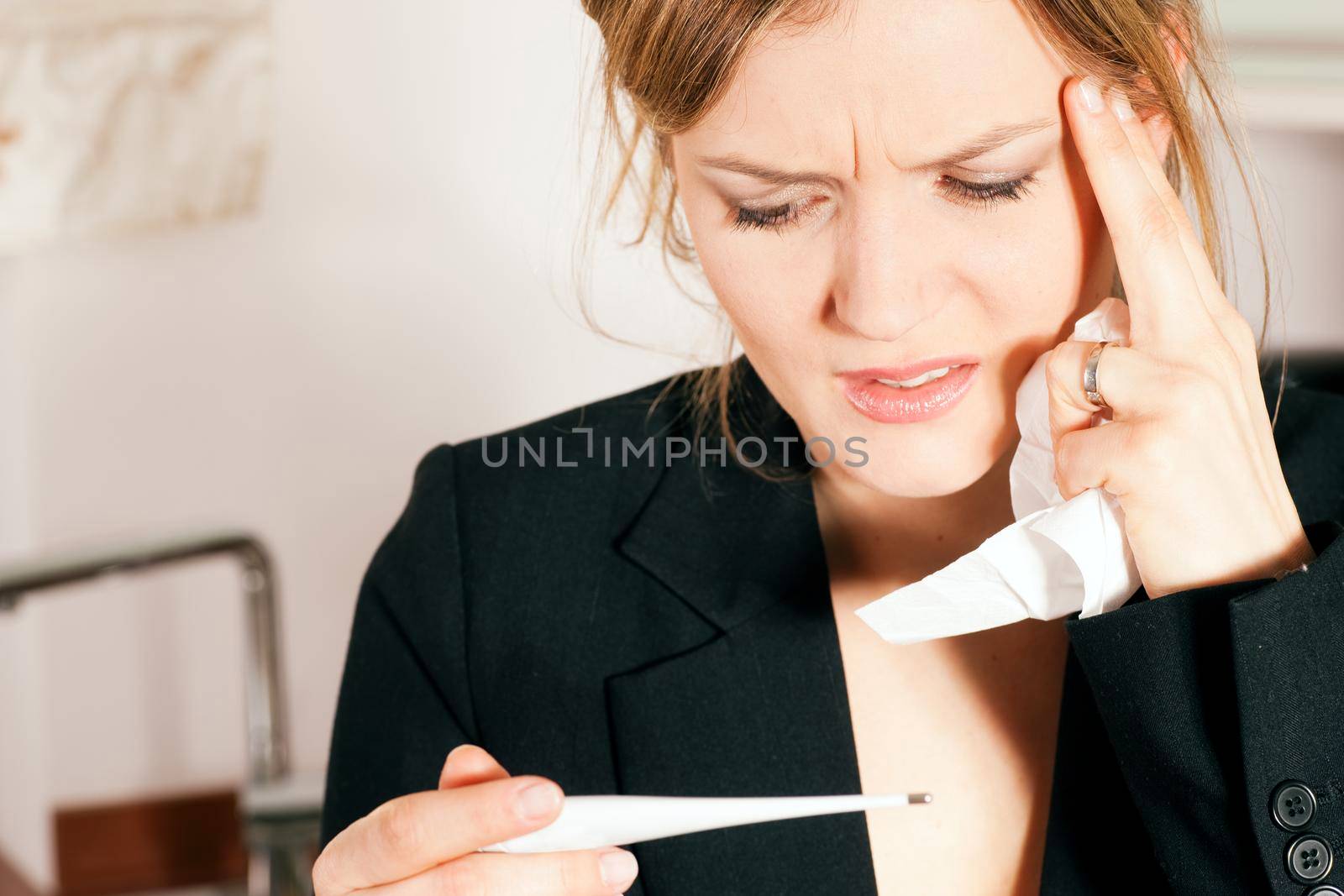 Woman having fever, and a cold or flu, taking her temperature with a thermometer