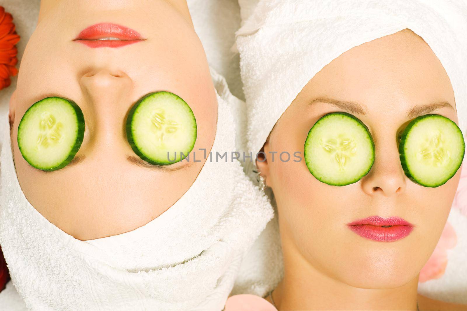 Girls in a beauty treatment with cucumber slices