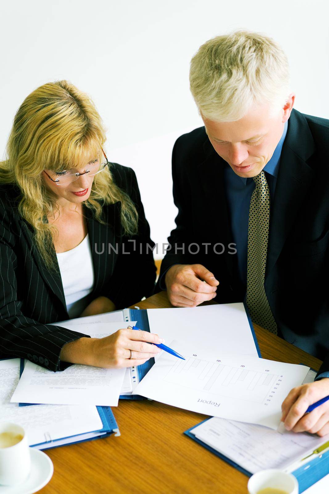 Two business people discussing a report