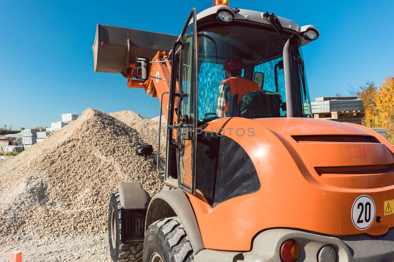 Worker on construction site operating wheel loader diligently