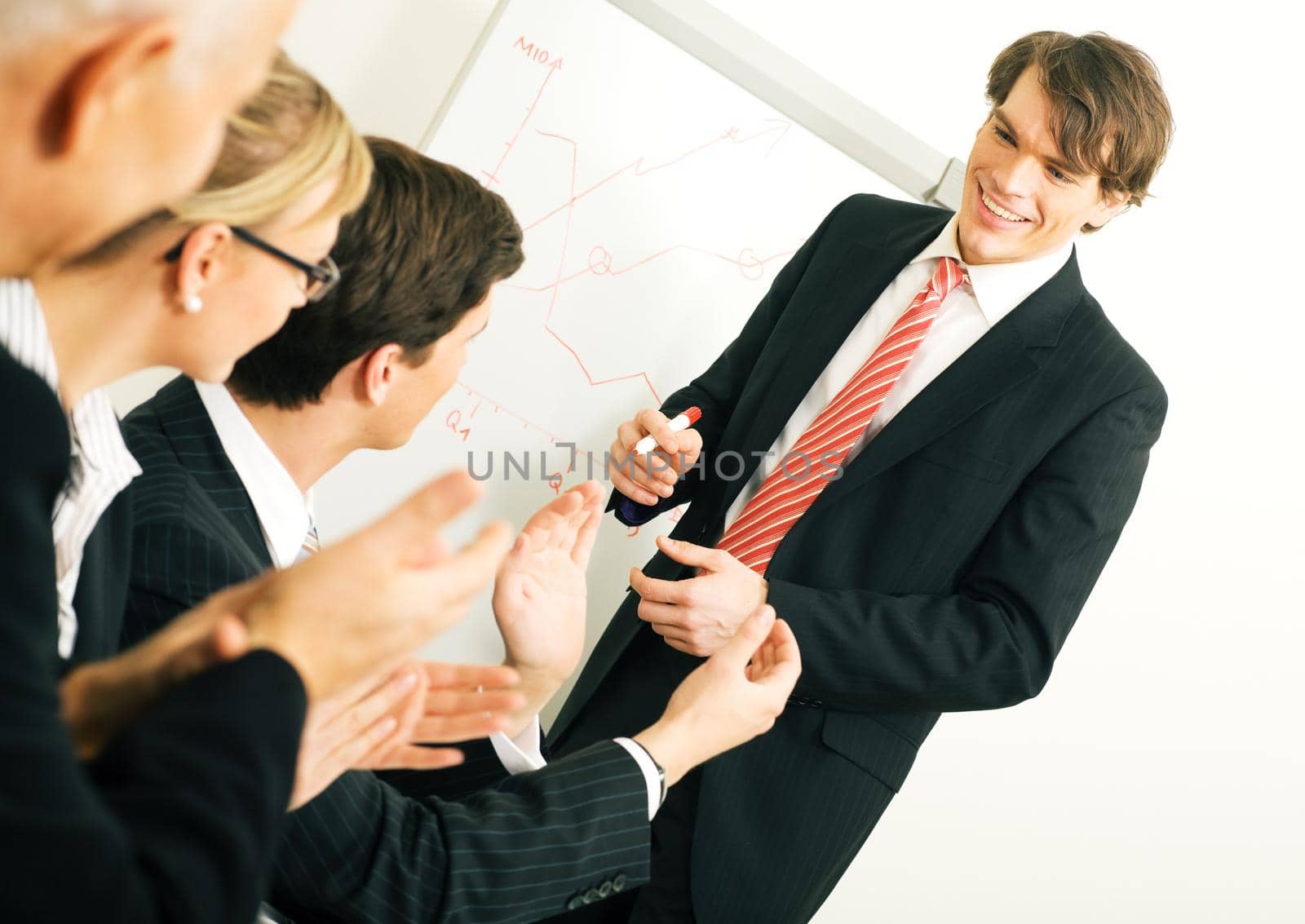 Business team applauding after a successful business presentation (selective focus only on the presenter!)