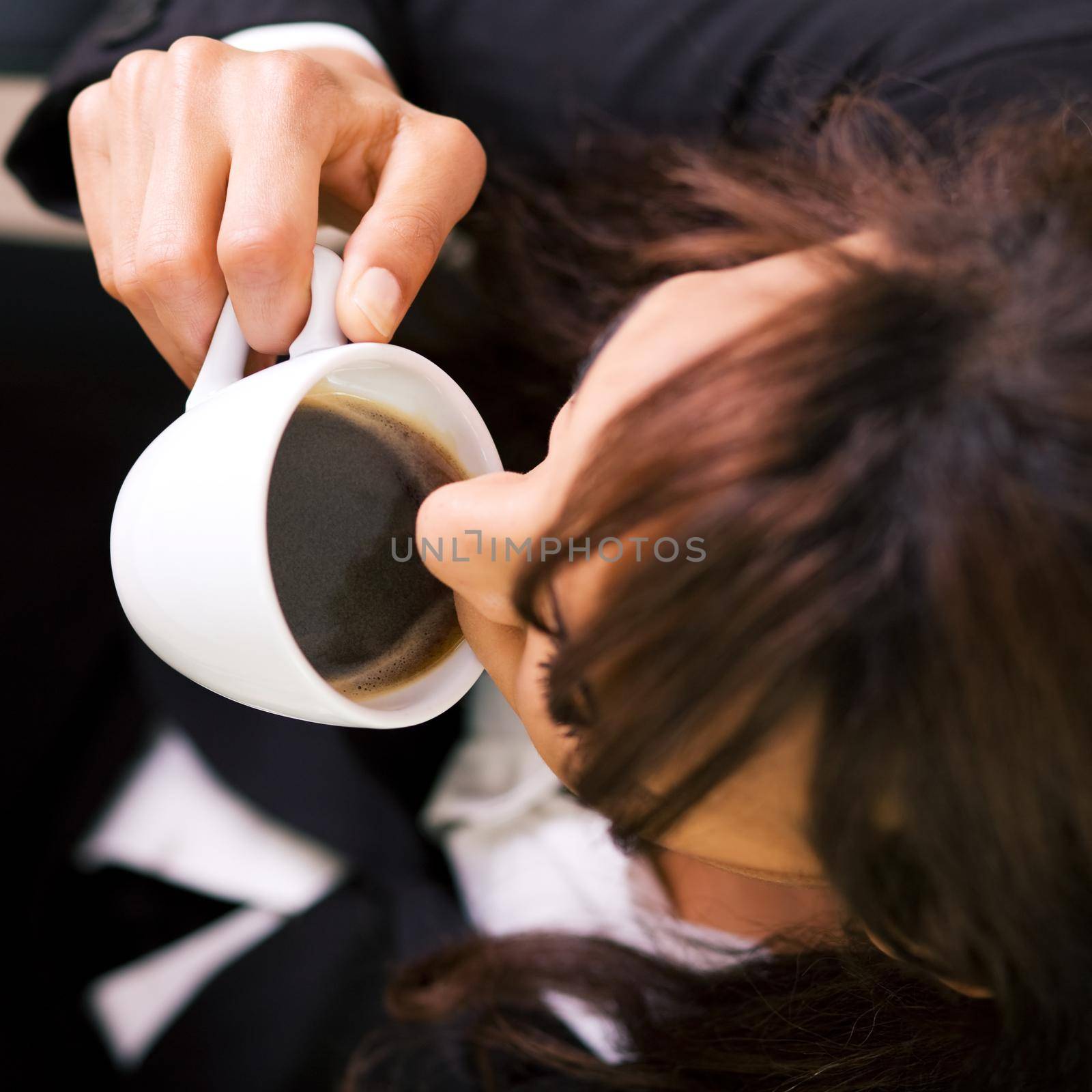 Woman pictured from above having a double espresso (shallow depth of field, focus on coffee)