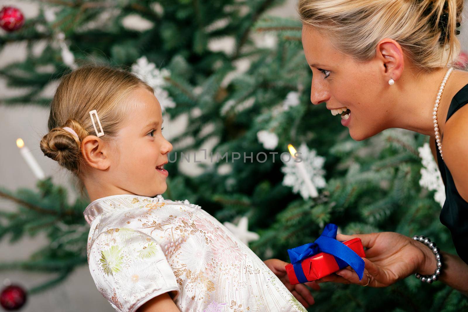 Young girl receives a gift by her mother