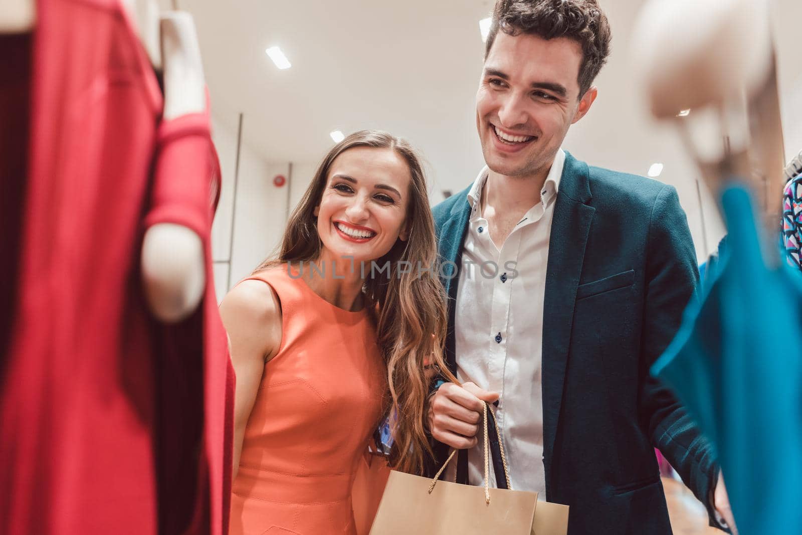 Couple craving for new clothes in fashion shopping spree testing the quality