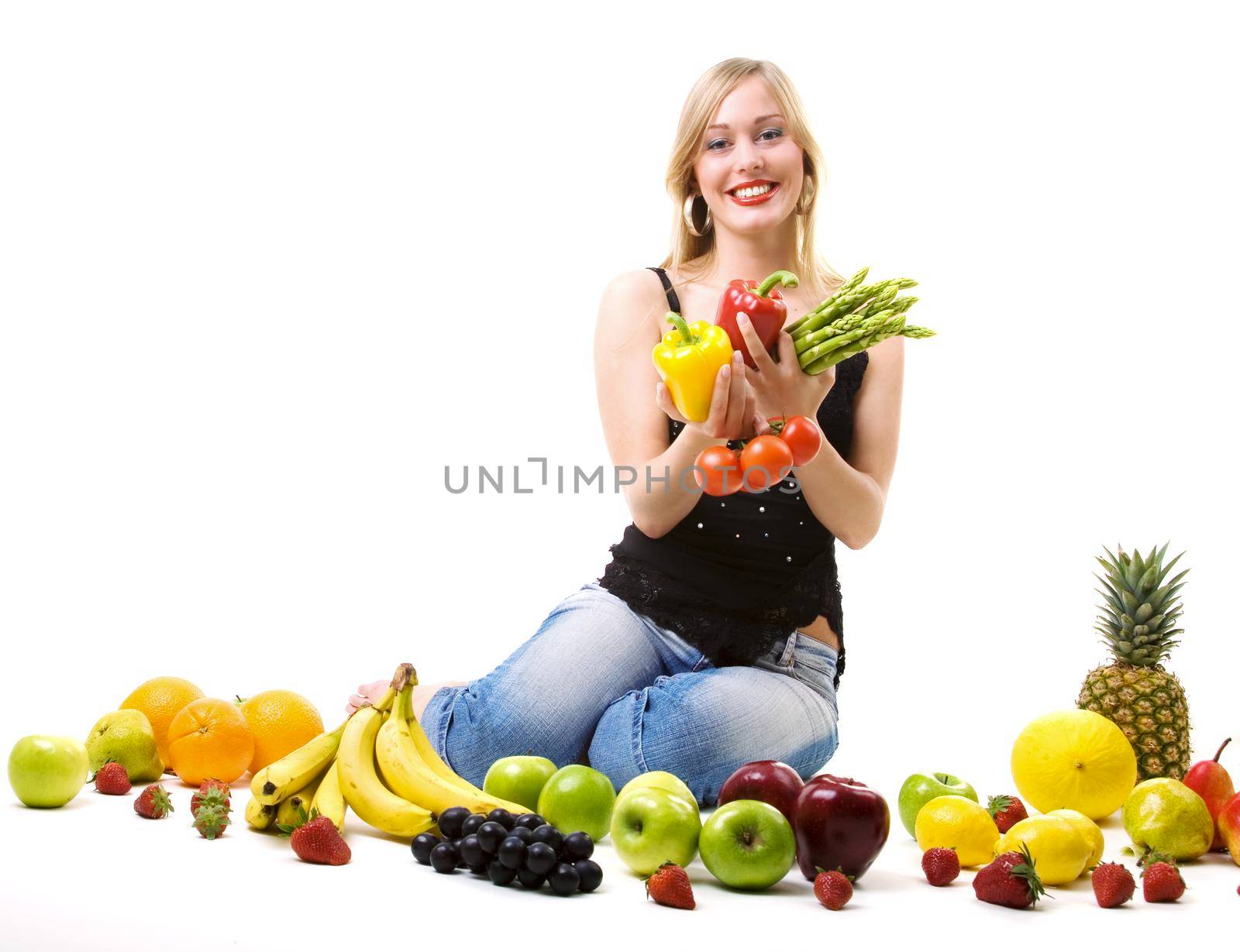 Beautiful woman sitting amidst fruits holding vegetables