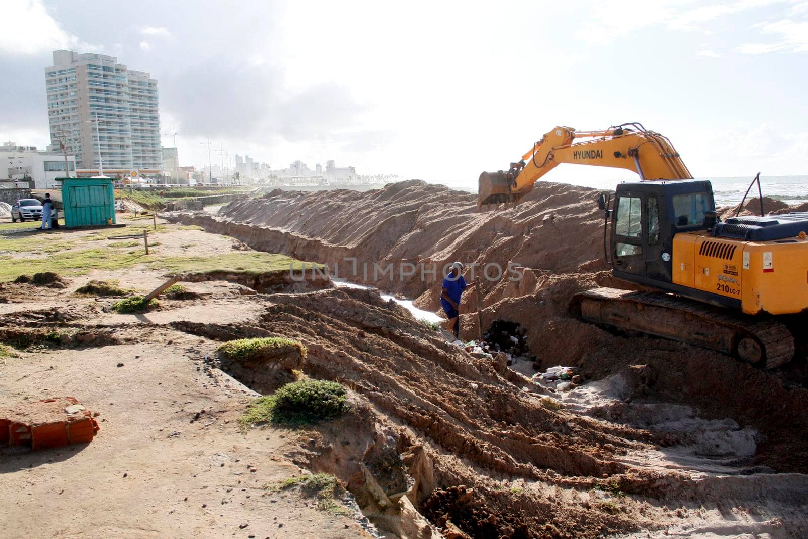 salvador, bahia / brazil - july 10, 2014: Excavator works on a work to recover the sea advance at Praça Wilson Lins, in the Pituba neighborhood in the city of Salvador.


