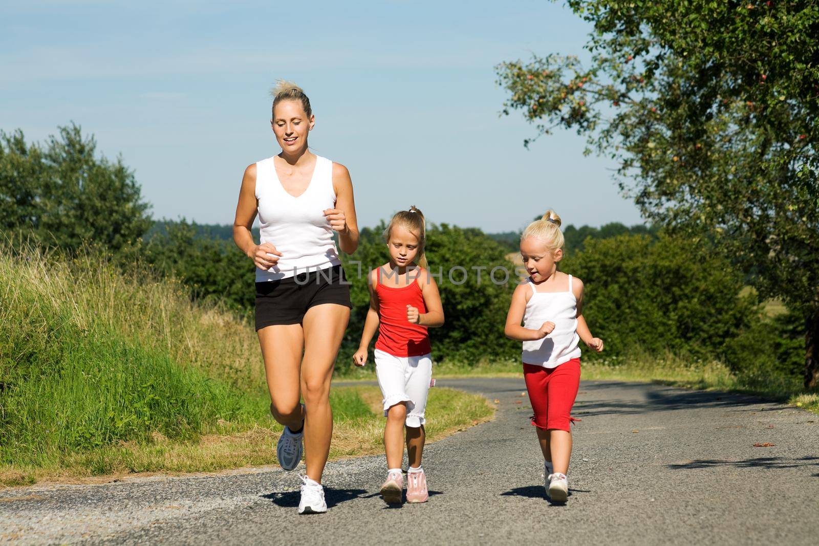 A young mom running with two daughters