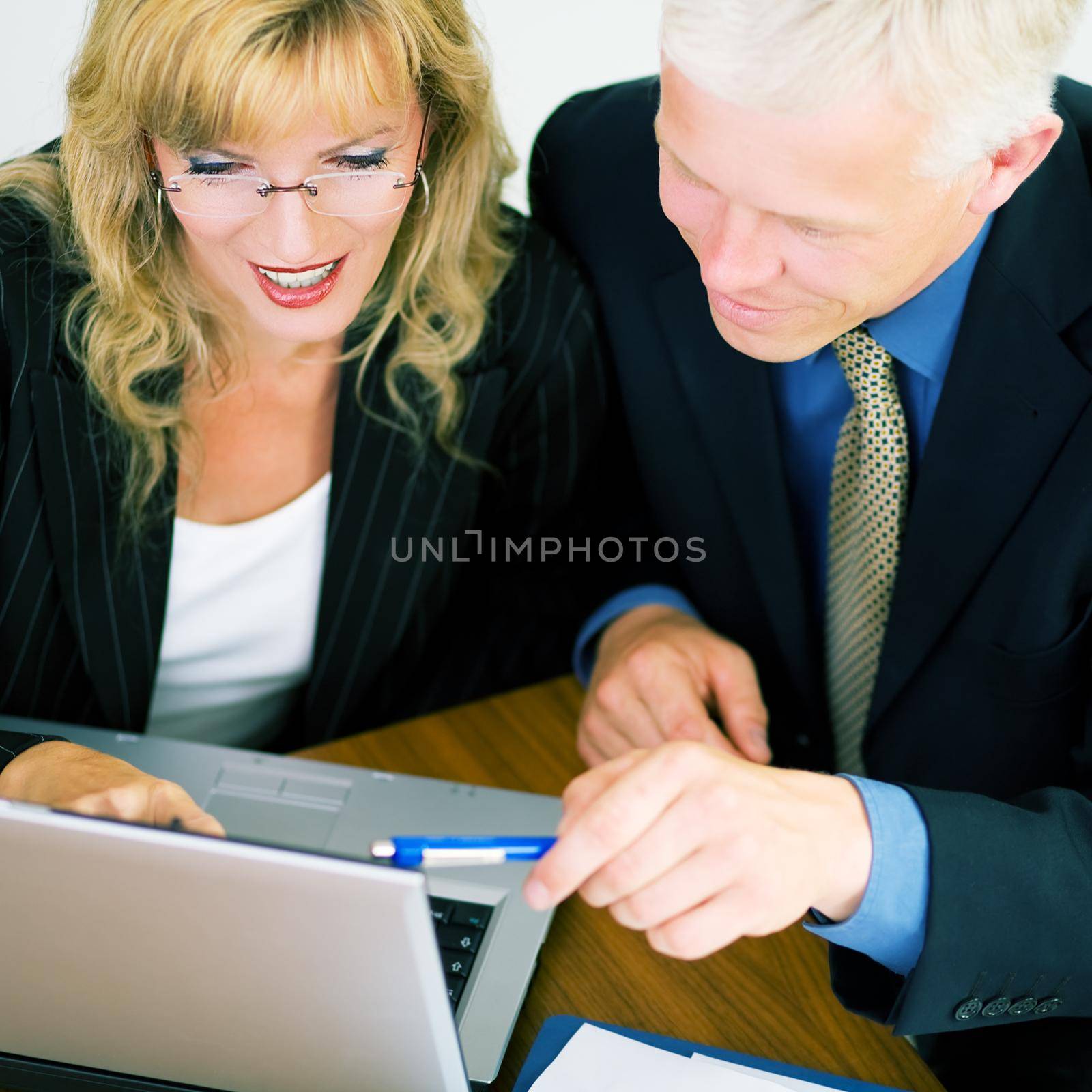 Business couple discussing an electronic document (shallow depth of field, focus on eyes of the woman)