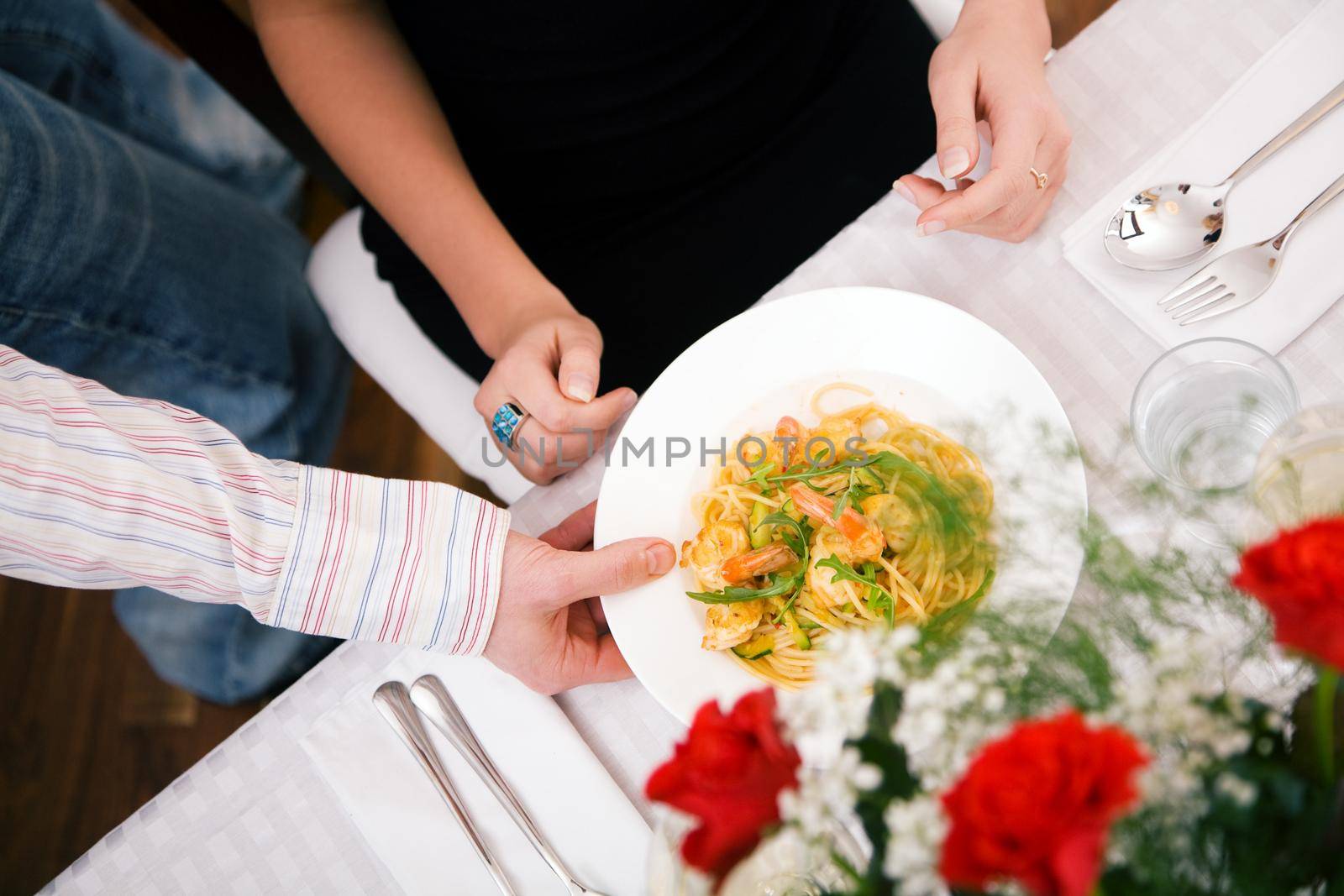 Young couple romantic dinner: he shows her what he has cooked - pasta