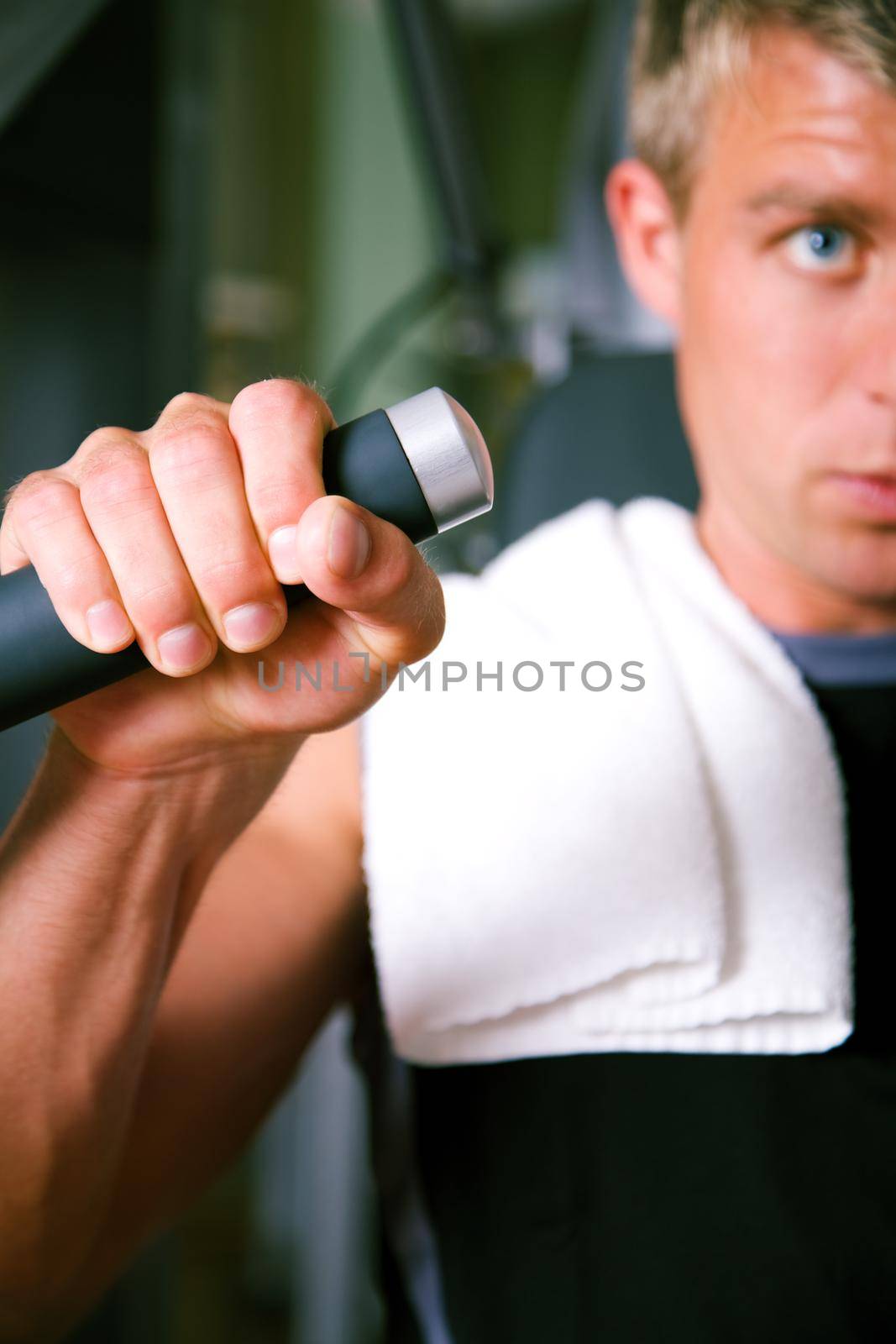 Man lifting weights in a gym, closeup on his hand
