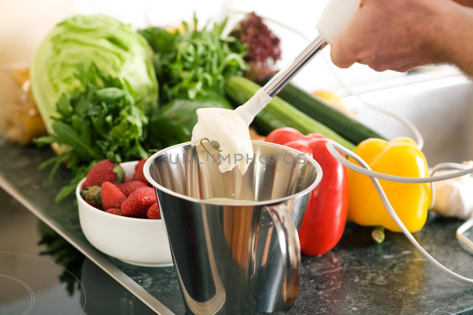 Cook preparing cream using a kitchen mixer