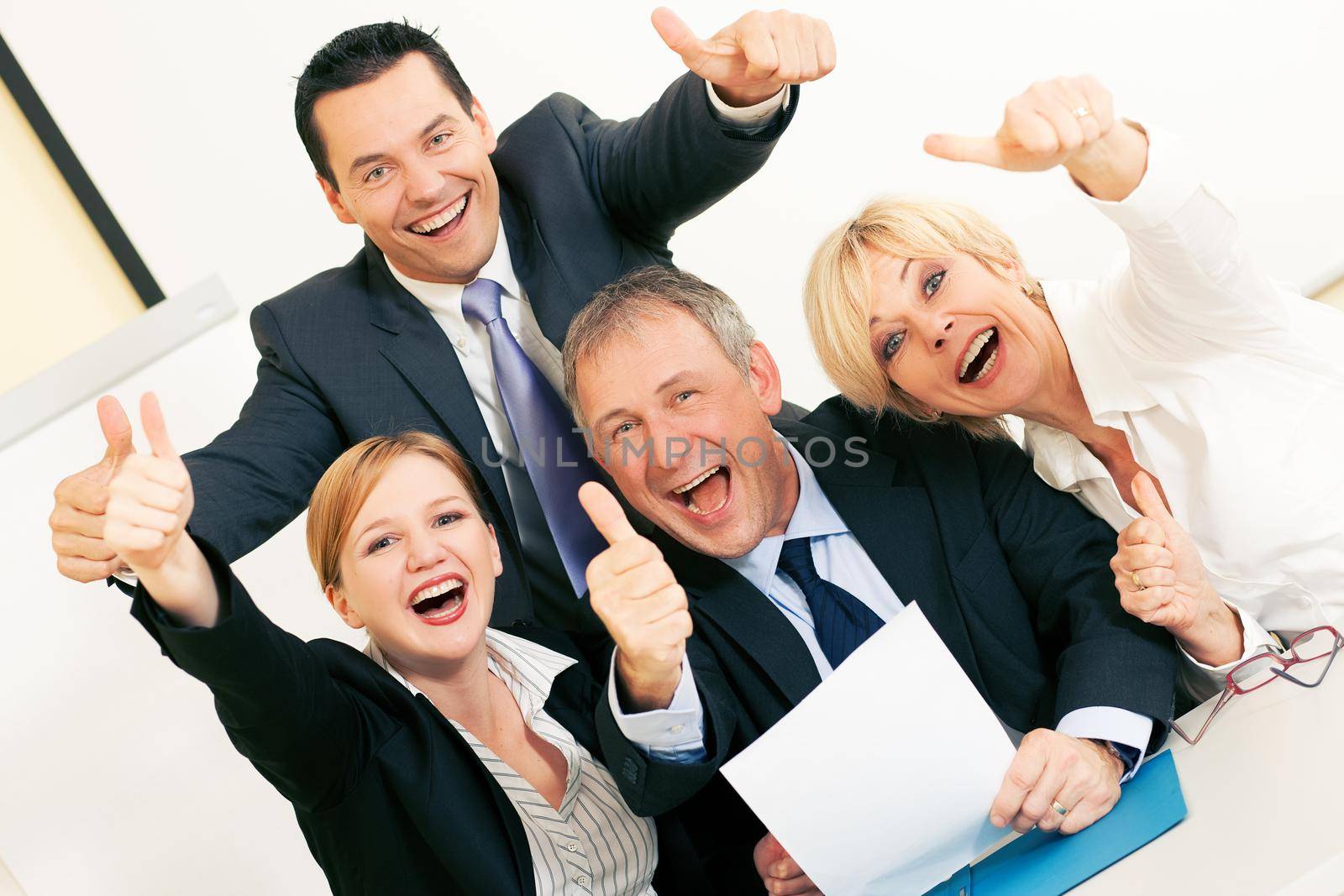 Business people having a lot of fun and letting it show by doing the thumbs up sign, celebrating a success