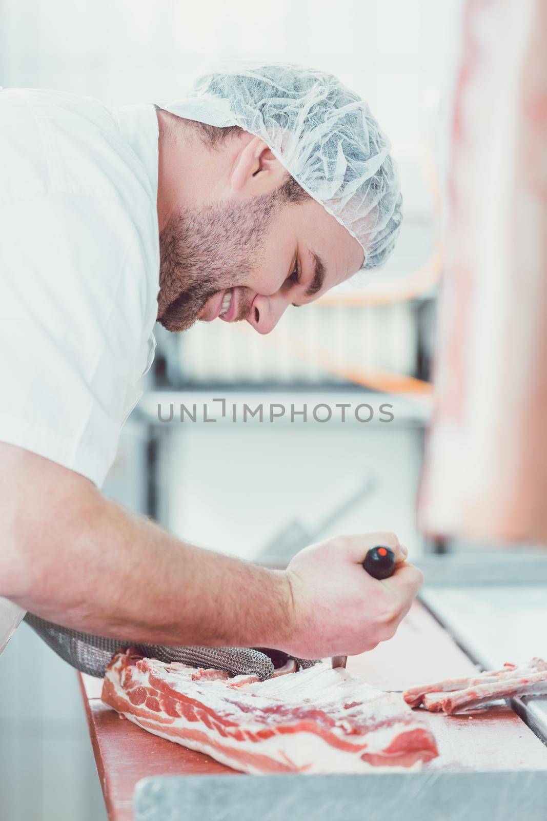 Pork Meat being processed in a butchery by man