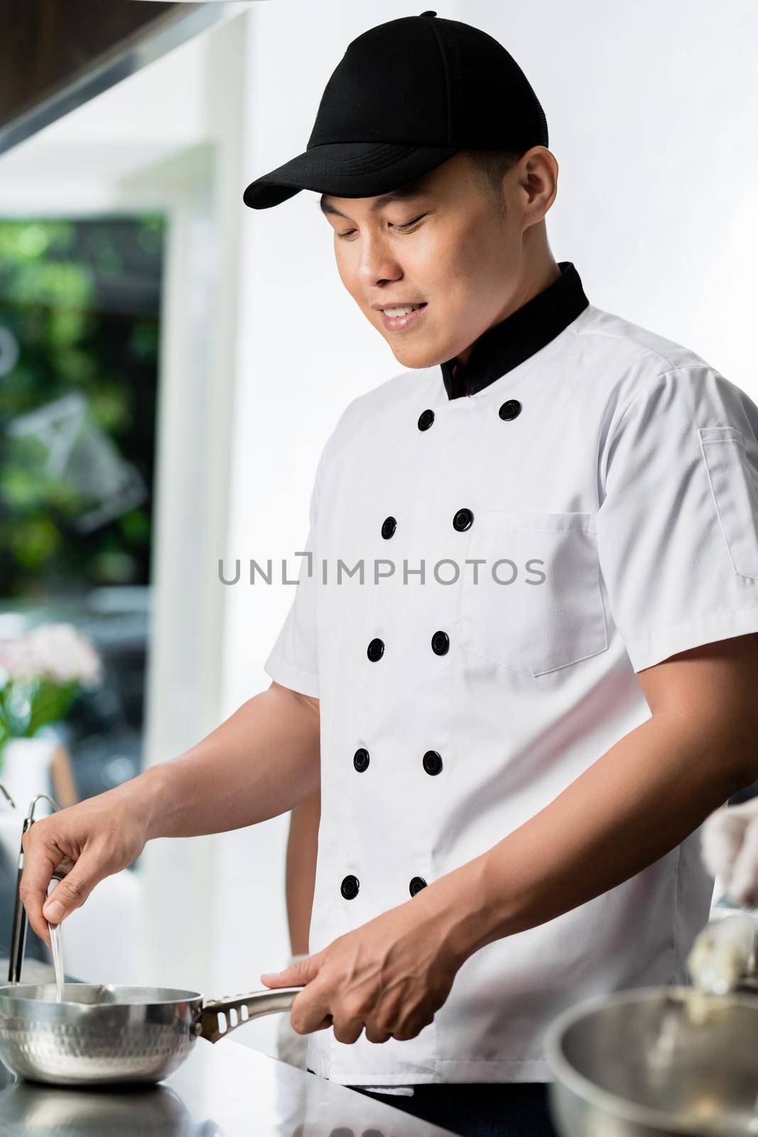 Chef cooking in a commercial kitchen by Kzenon