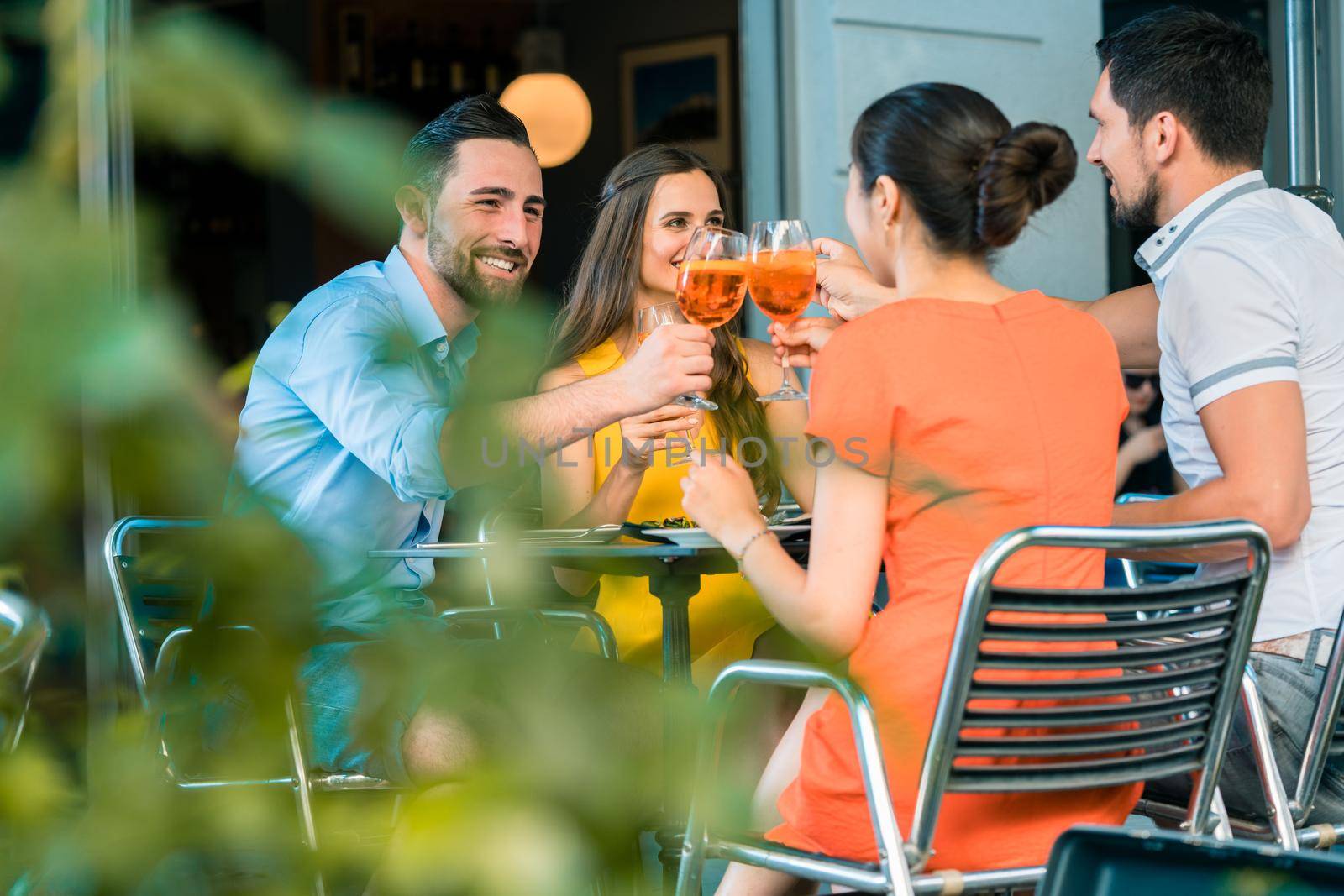 Cheerful friends toasting with a refreshing summer drink by Kzenon