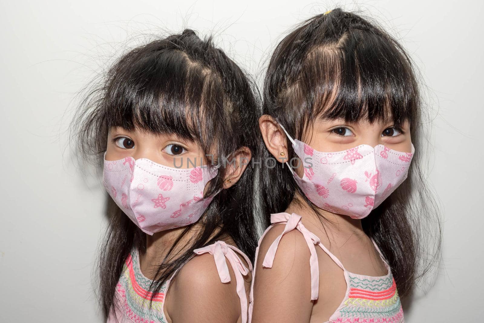 Asian female twins wearing a mask to protect against the Corona virus that can spread through the air