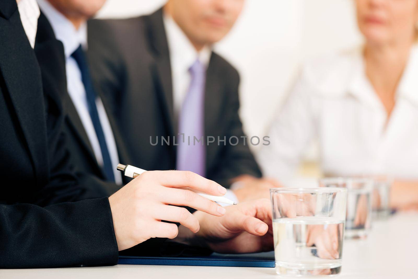 Small business team or working group having a brainstorm meeting in the office, very close-up shots on details, focus on hands in front