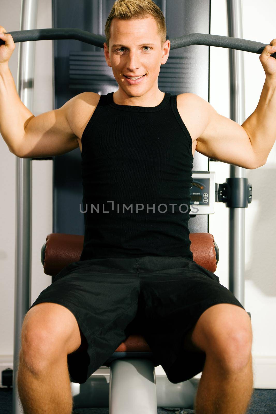 Man doing fitness training in the Gym on an exercising machine