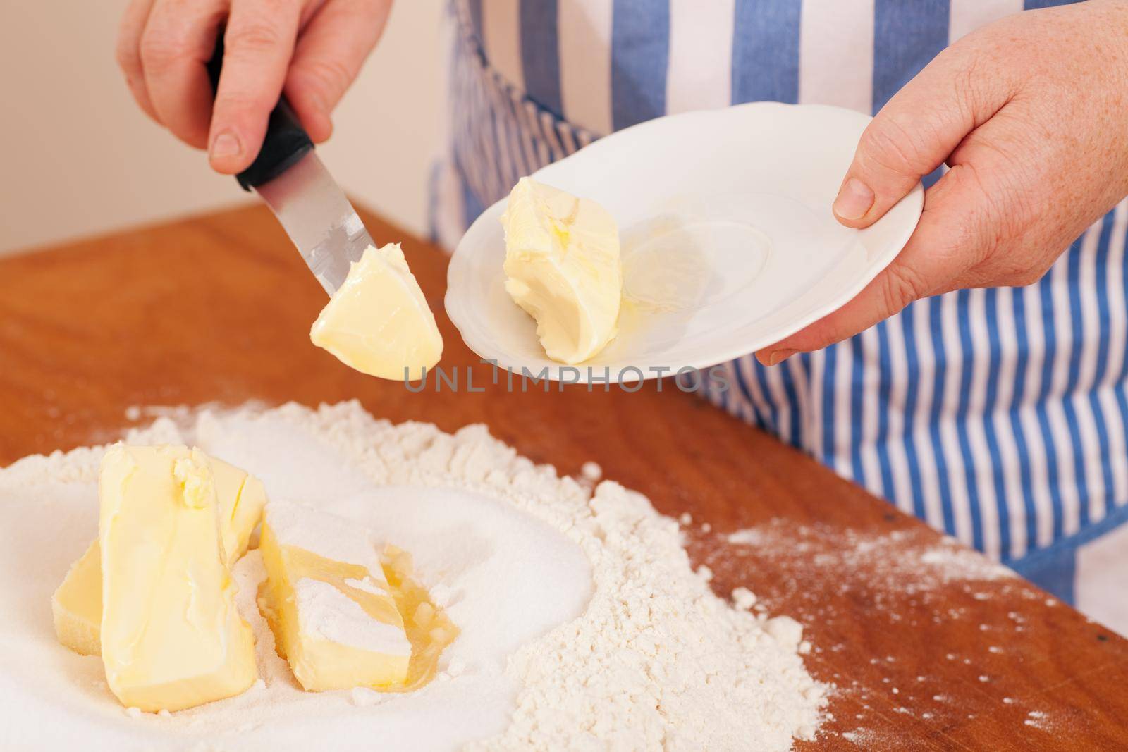 Baking biscuits, woman putting butter in the flour