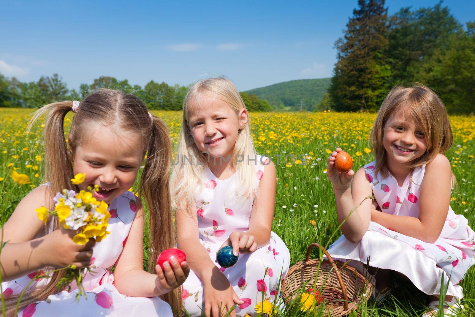 Children on Easter egg hunt with eggs by Kzenon