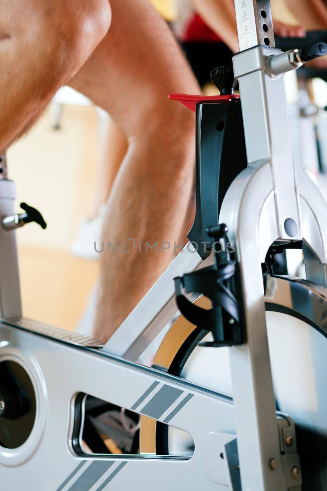 Three people spinning in the gym, exercising for their legs and cardio training