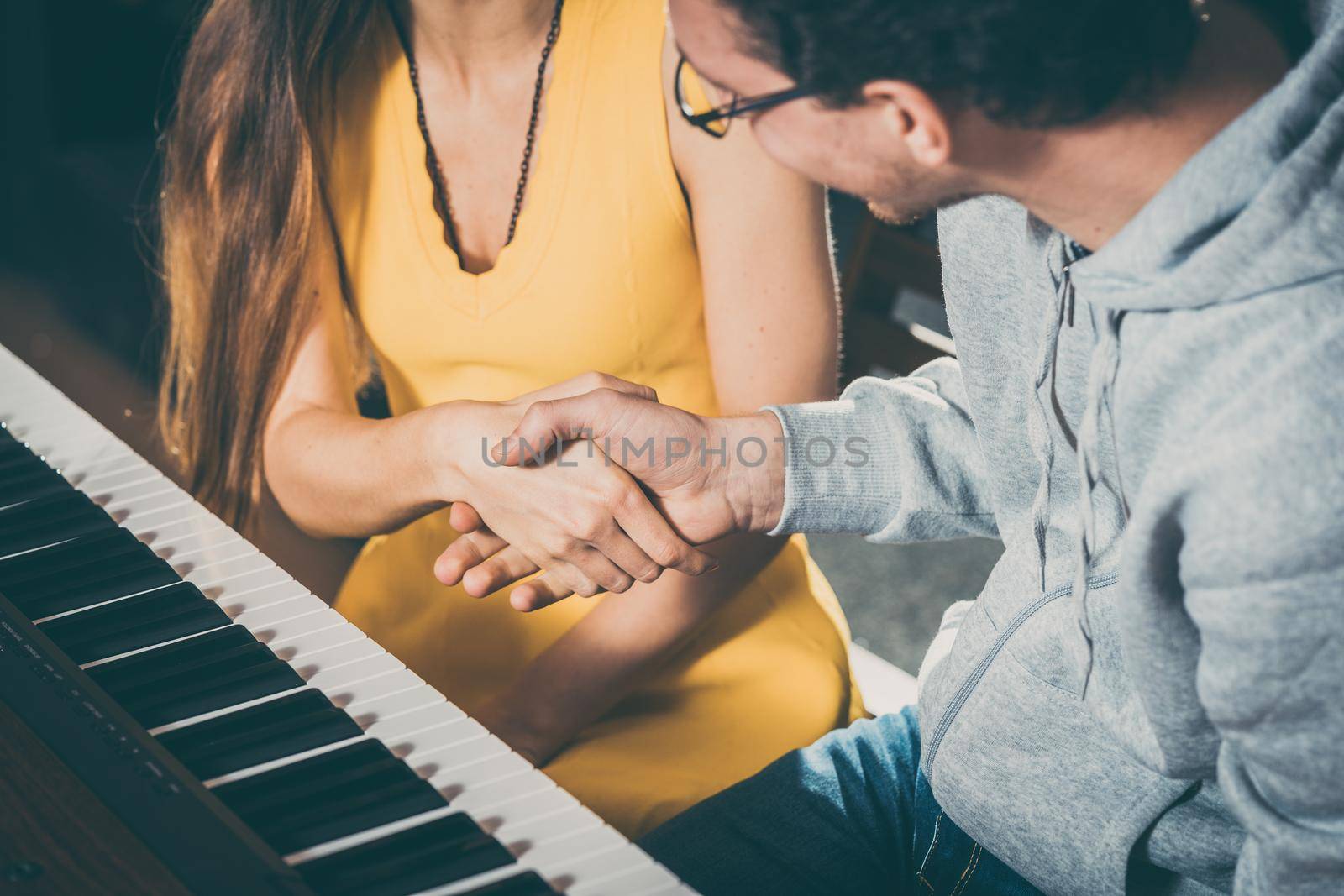 Piano teacher and student shaking hands after music lesson