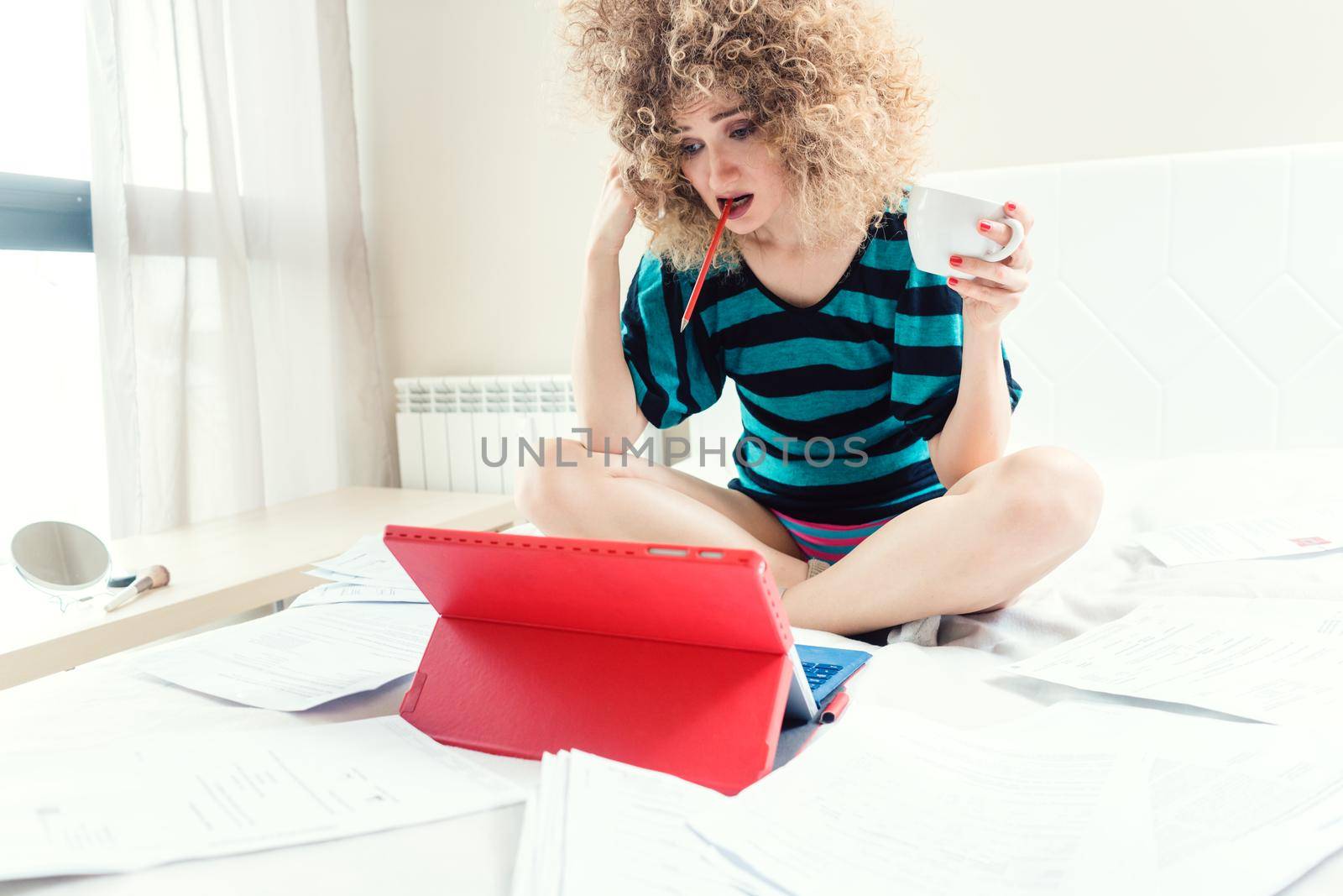 Telecommuting woman being desperate having no clue working on her bed