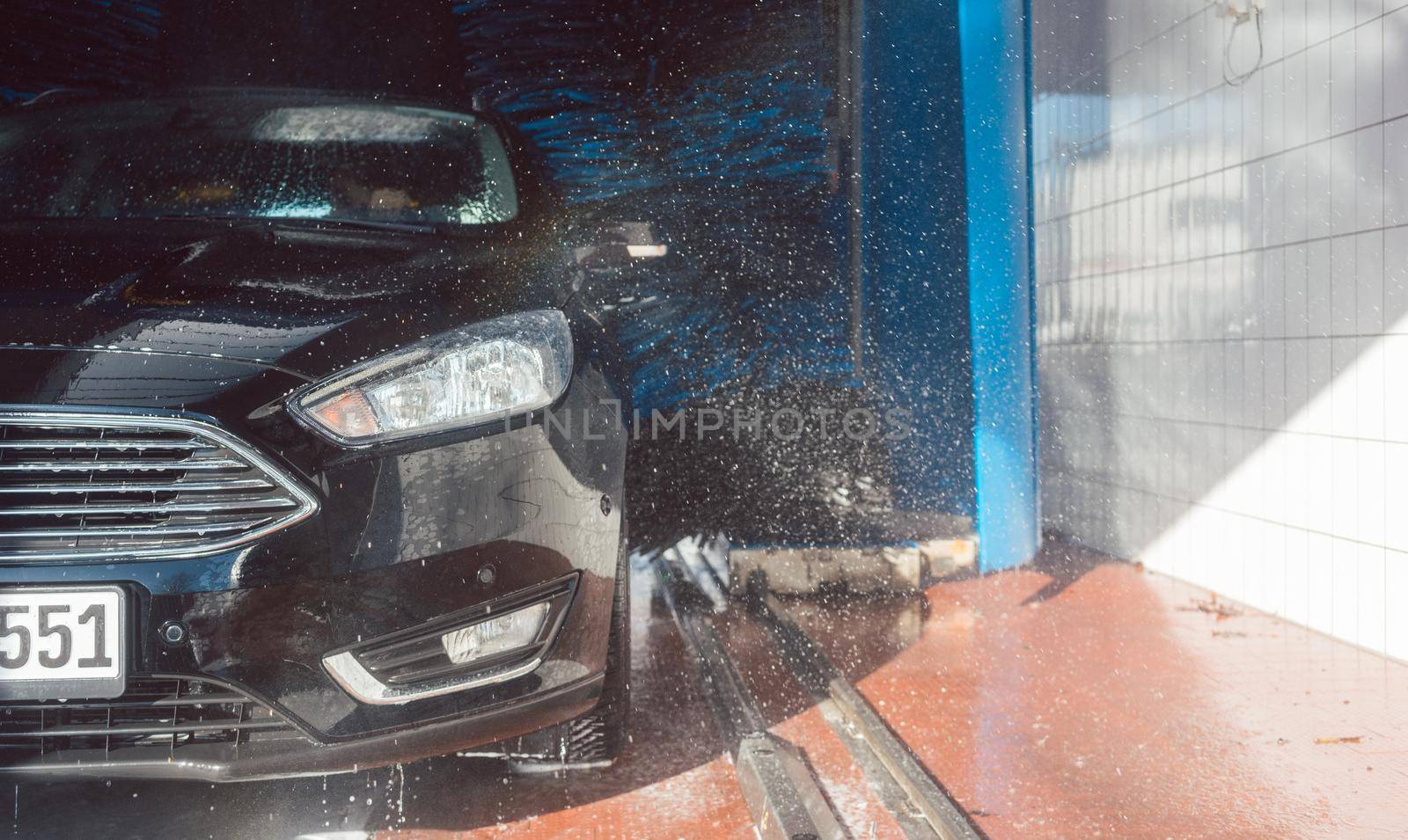 Brush turning in car wash with vehicle in it