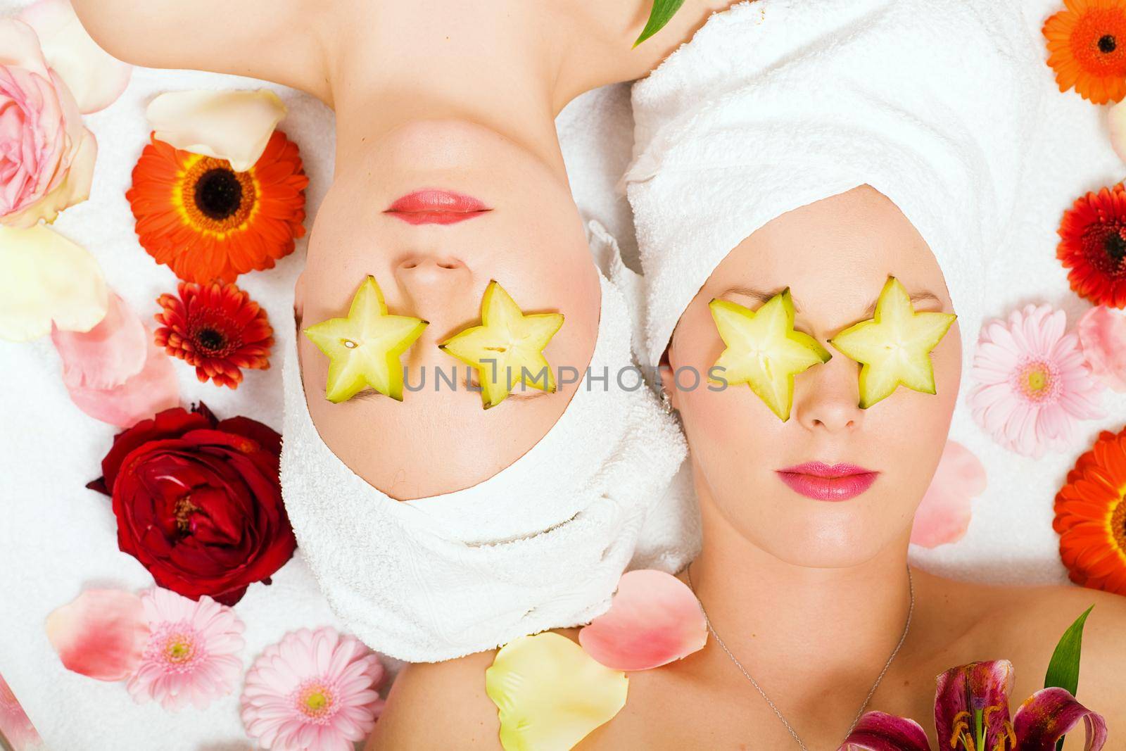 Girls in a beauty treatment with star fruit slices on their eyes