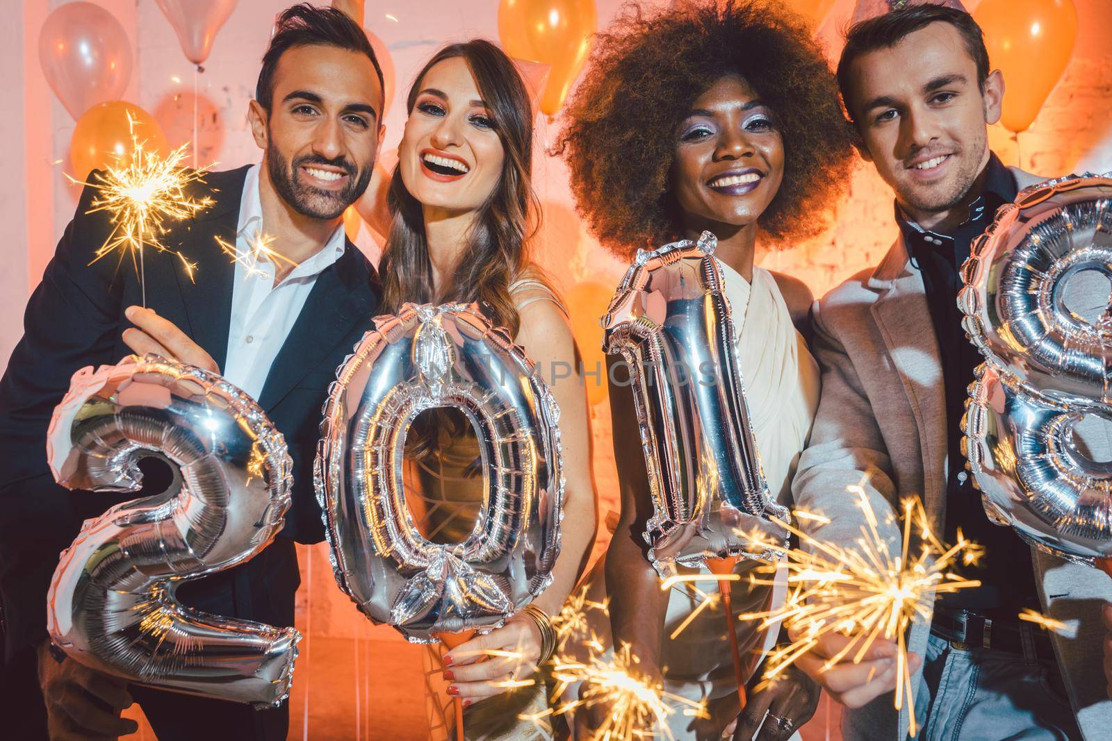 Group of party people celebrating the arrival of 2018, men and women looking into camera