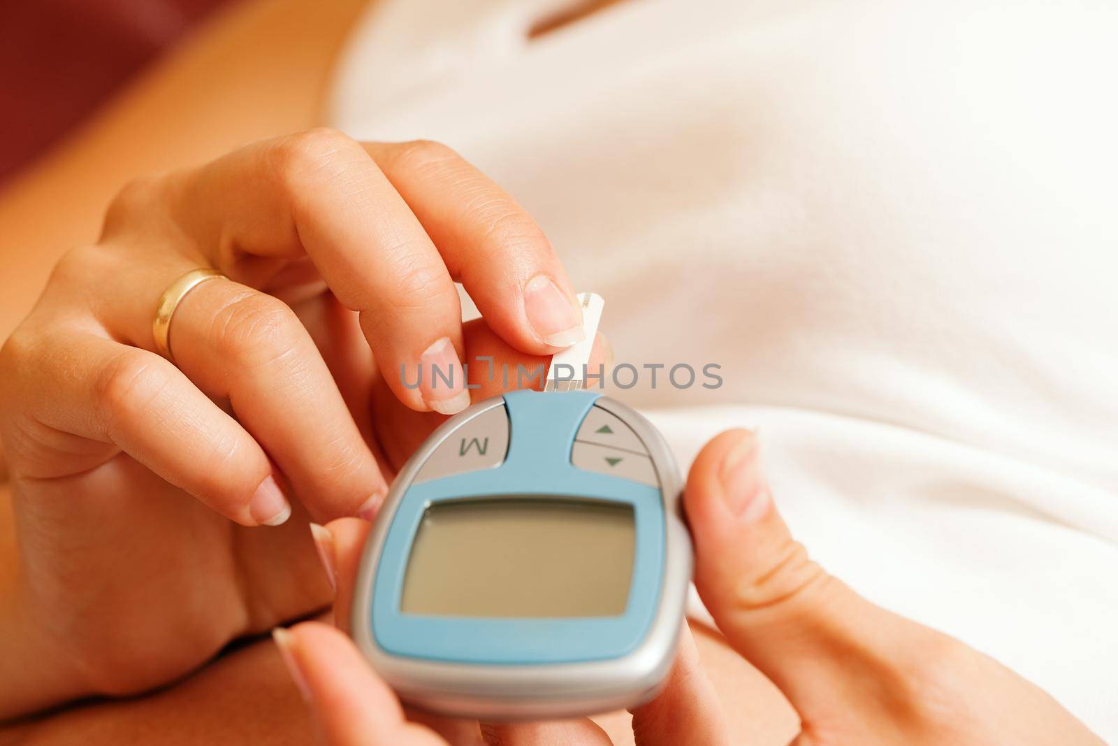 Woman testing glucose for diabetes by Kzenon