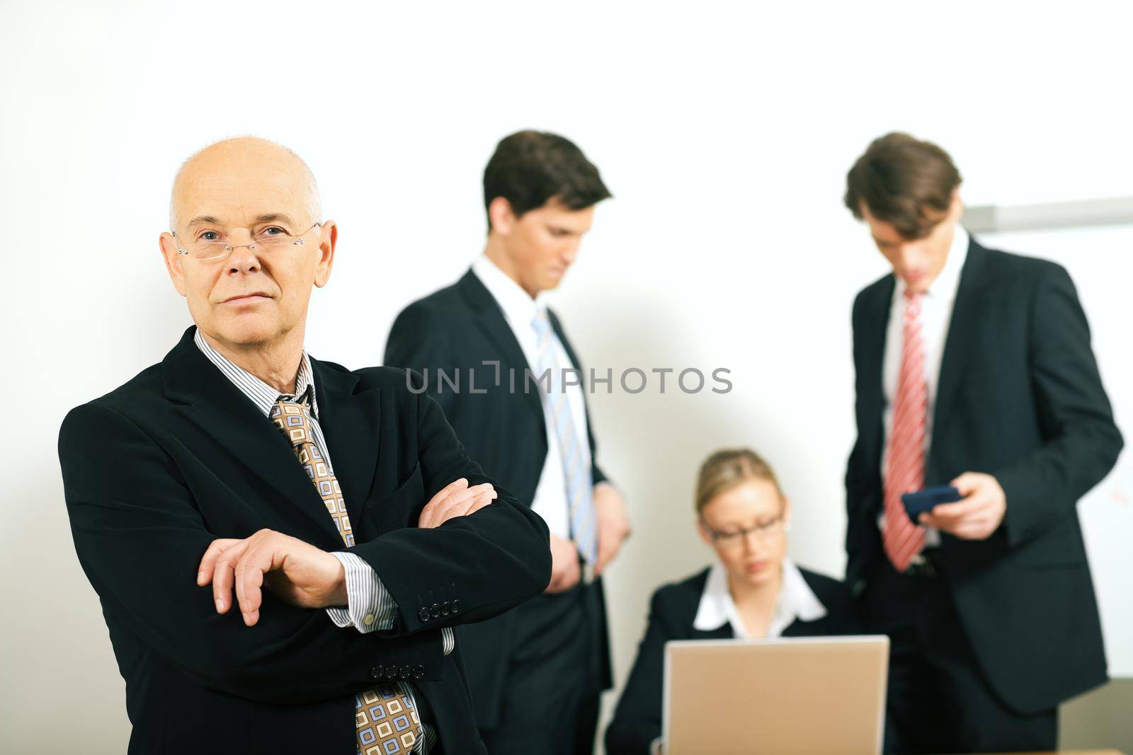 business team with a portrait of the very confident team leader in foreground (selective focus only on the team leader!)