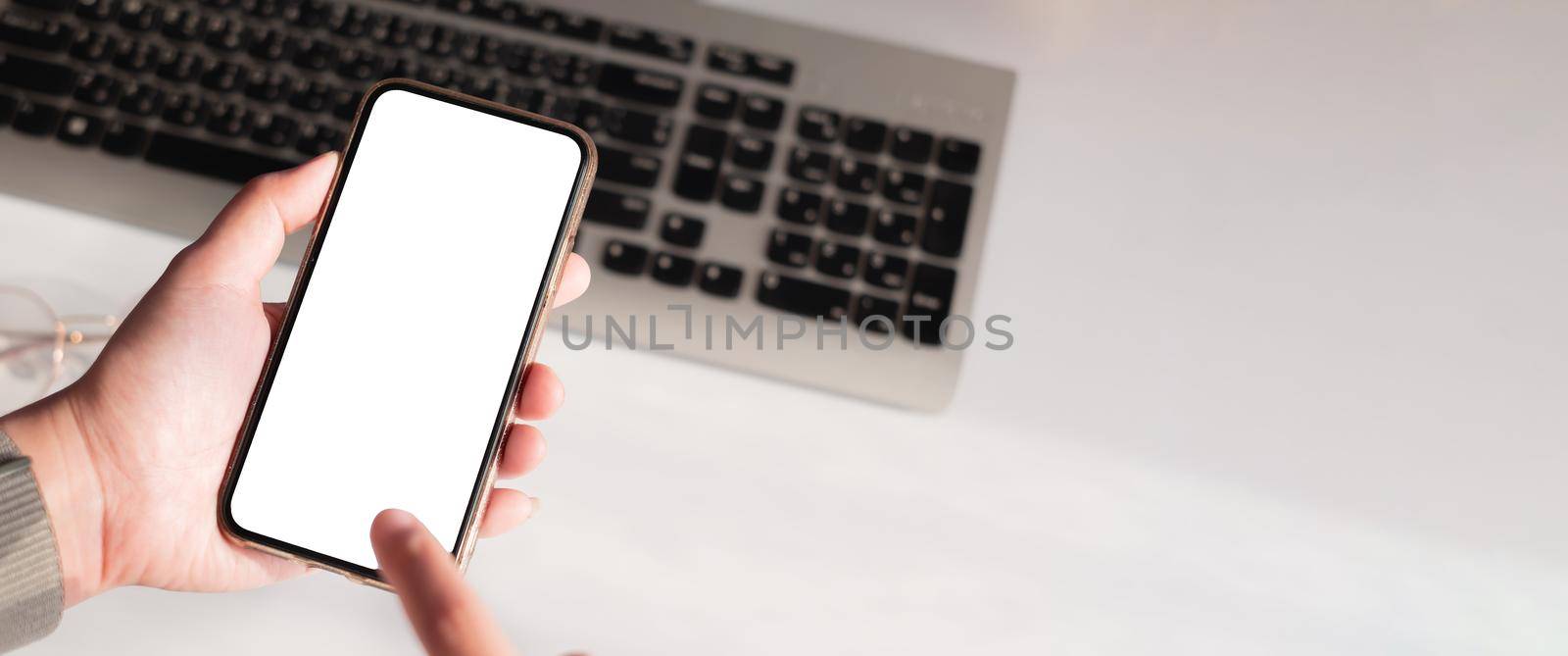 Hand of woman using smartphone over workplace.