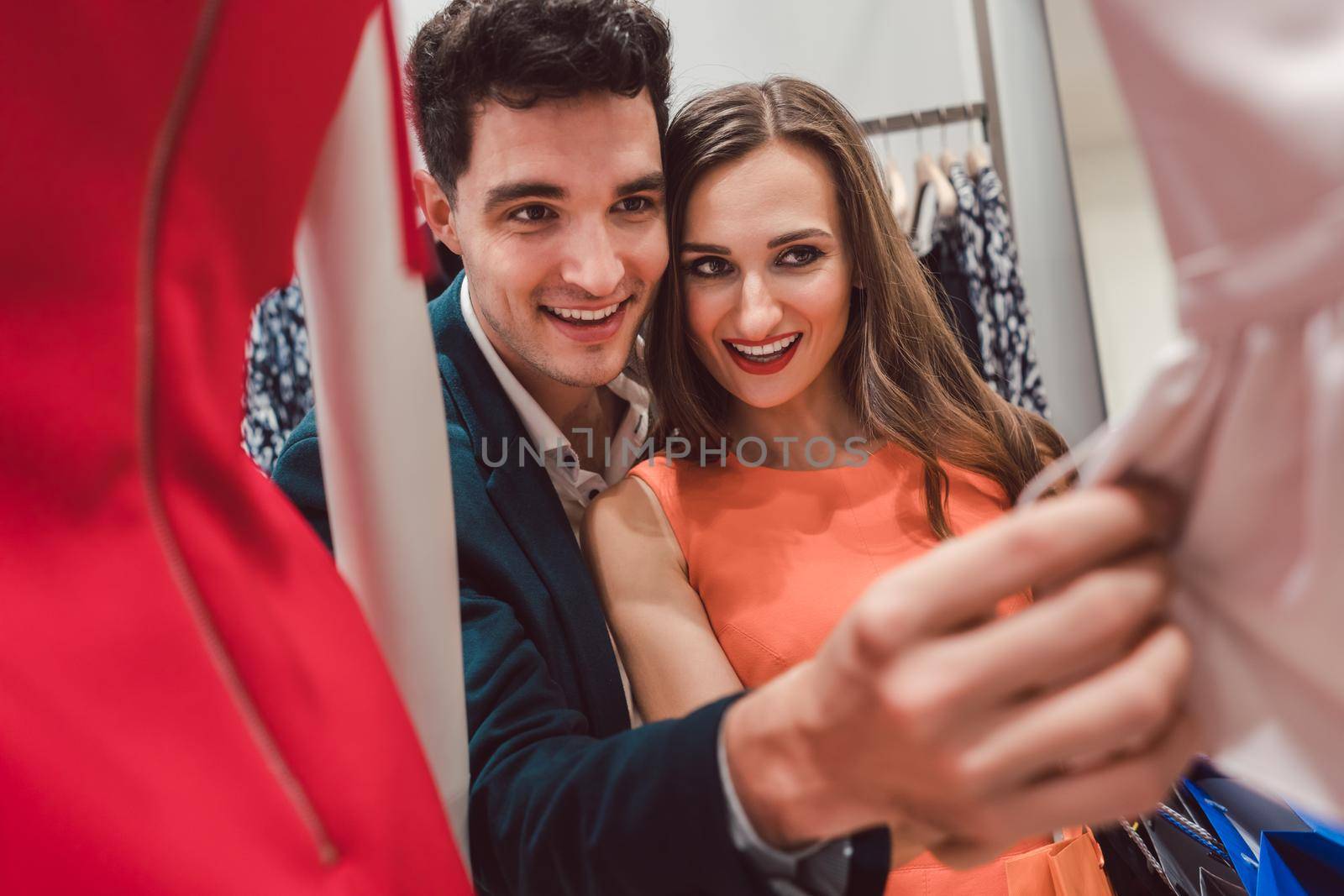 Woman and her man shopping for fashion looking through mannequins