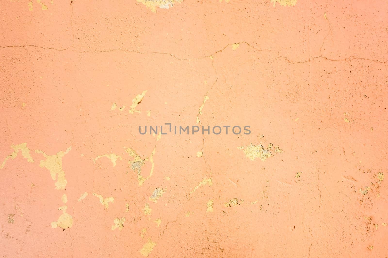 Old pink cracked stucco wall background texture