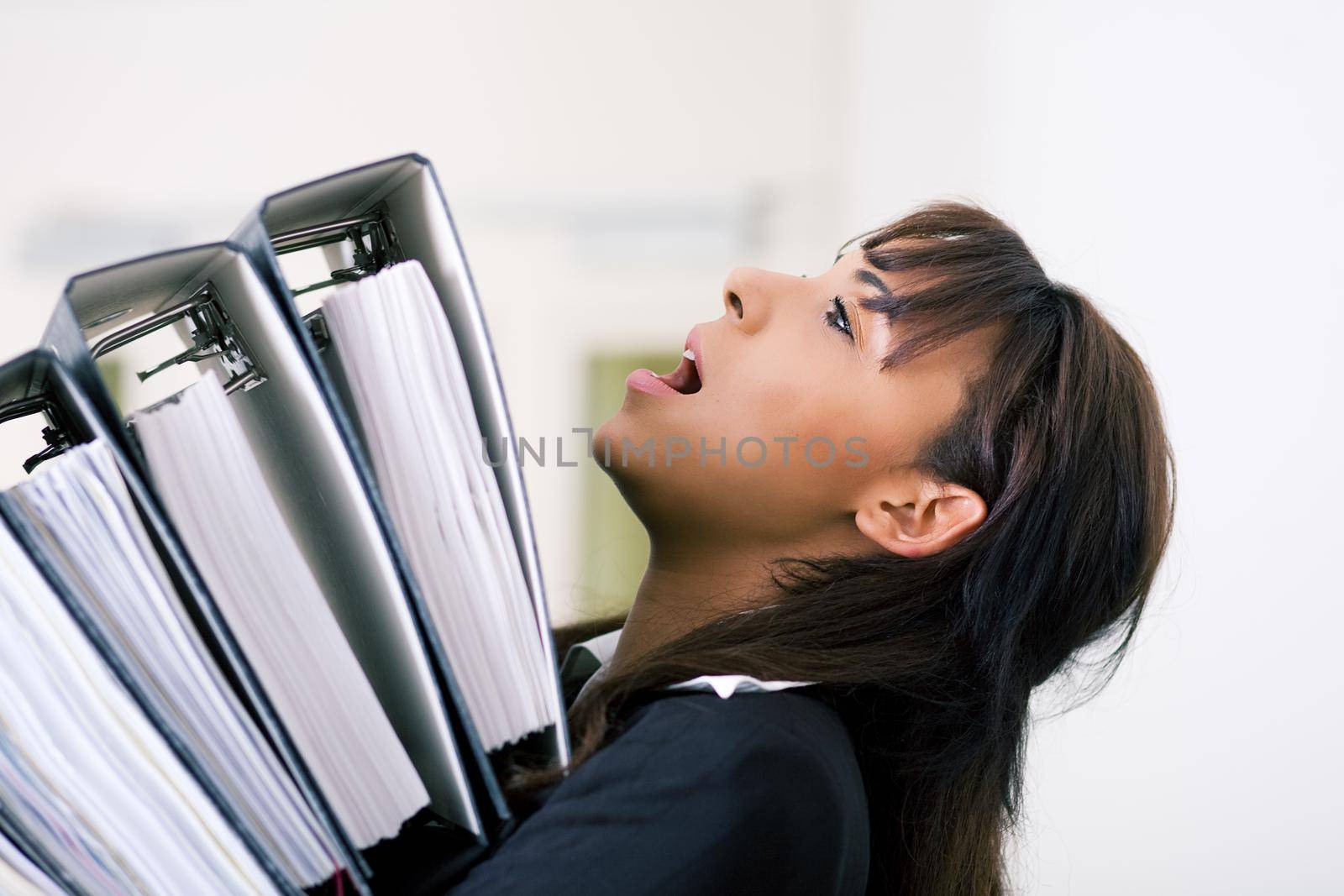 Secretary carrying more files that she can handle