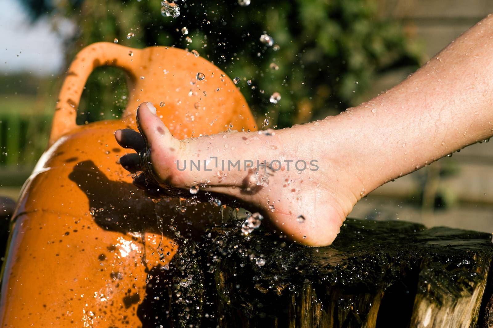 Splash of cold water showered on feet in an alternative therapy session; drops frozen