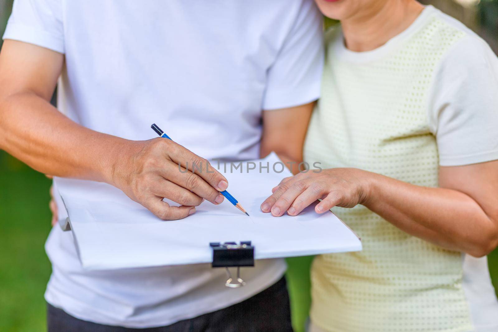 Asian middle-aged couple talking and designing garden plan together in backyard. by toa55