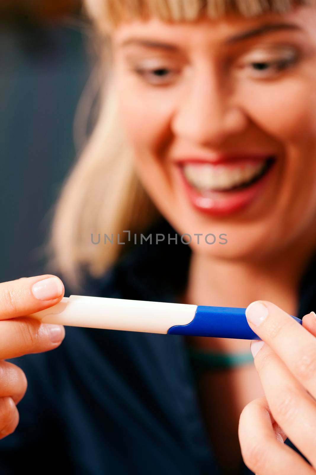 Woman looking at a pregnancy test being very excited upon the result