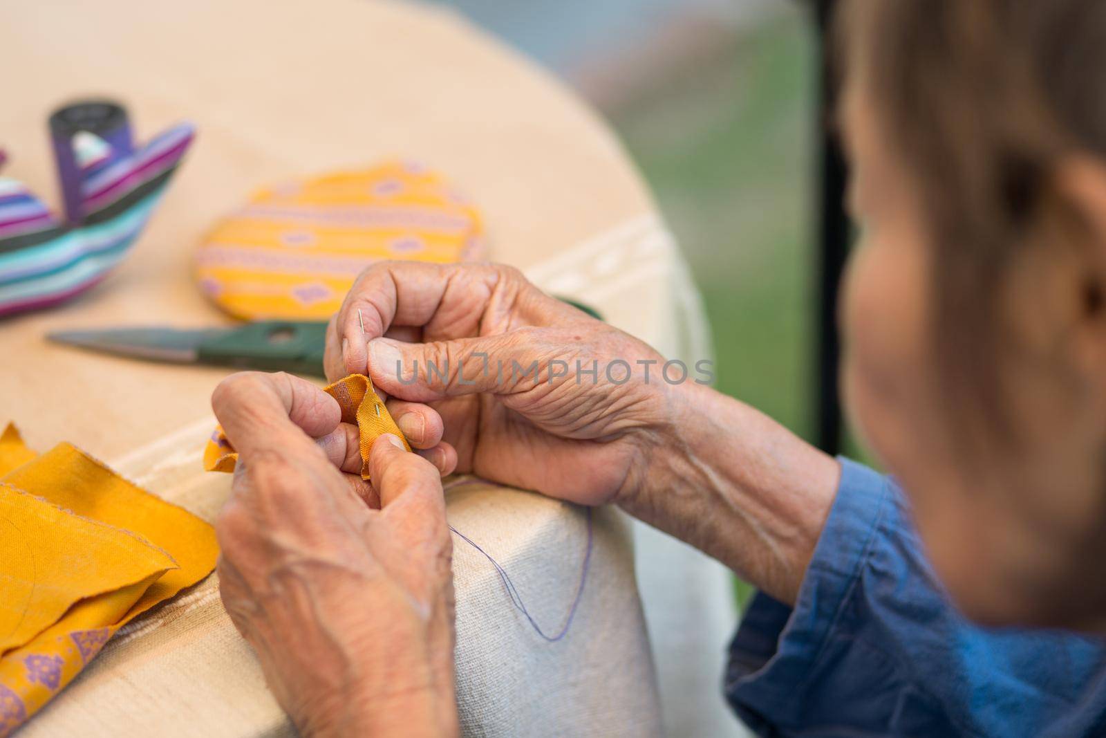 Elderly woman with caregiver in the needle crafts occupational therapy  for Alzheimer’s or dementia