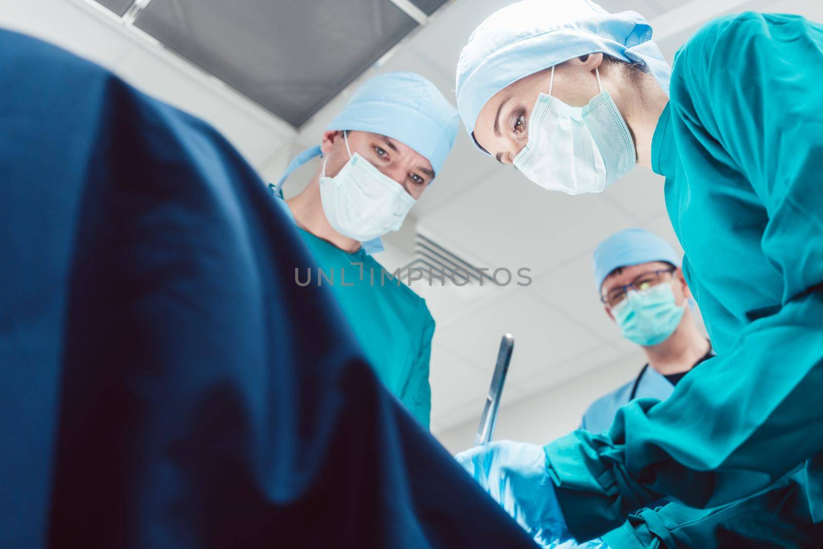 Team of surgeons in operation room during surgery from low angle view