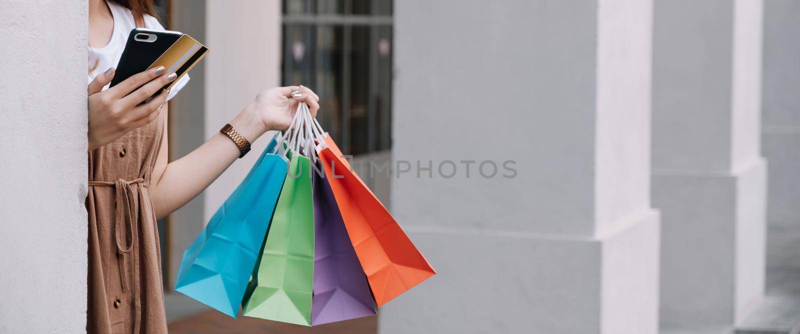 Closeup of woman holding shopping colourful of shopping bags on the street with copy space - Shopping Concept by nateemee