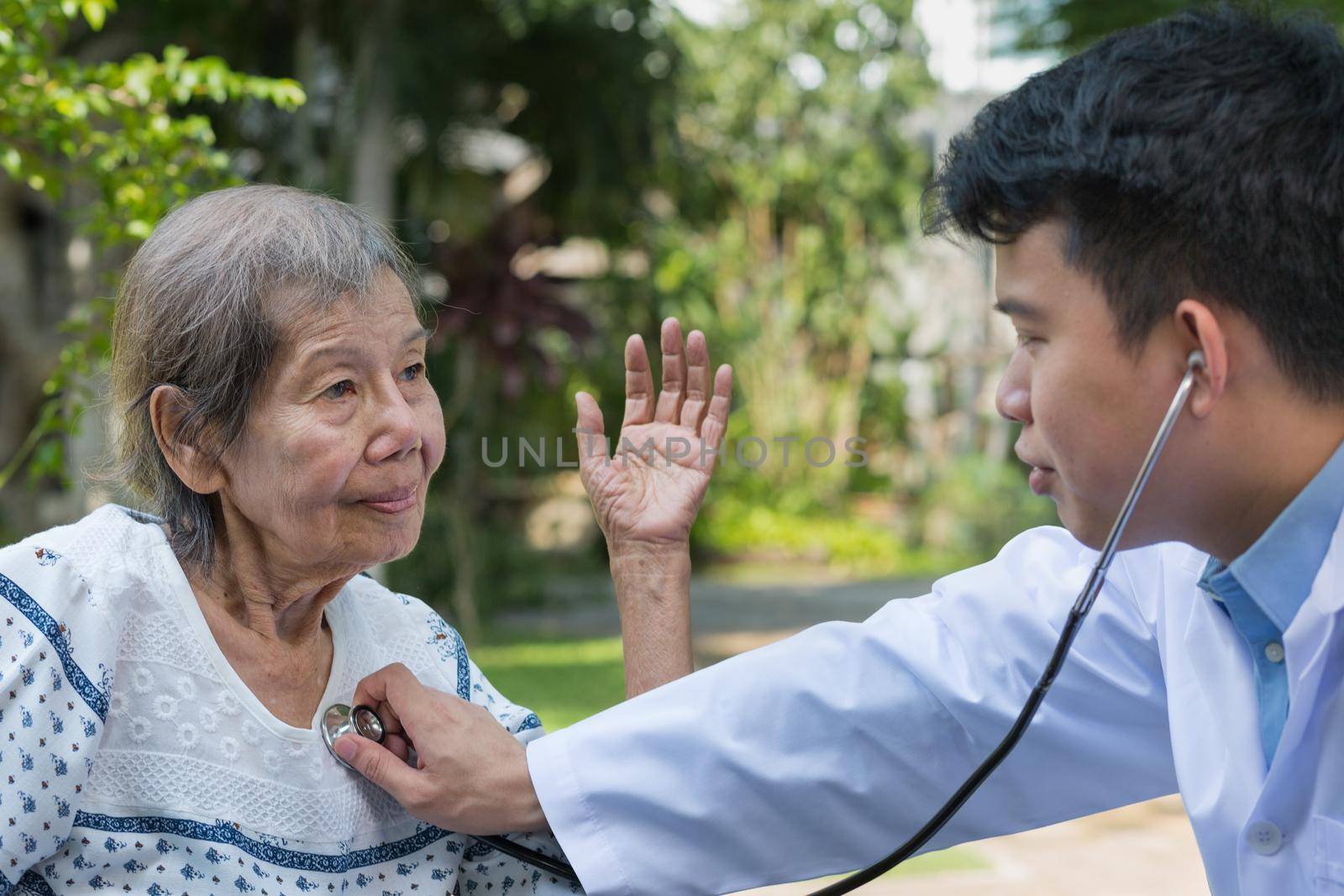 Doctor checking lung of elderly woman during homecare medical by toa55